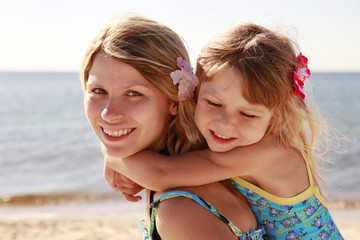 Mama and her little daughter  on the beach