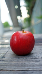one red apple on wooden table