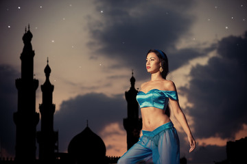 Arabian nights. Girl, silhouette of eastern palace, starry sky
