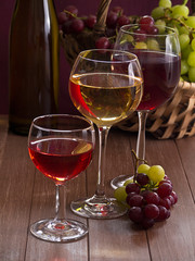 Wein im Weinglas mit einem Korb Weintrauben im Hintergrund