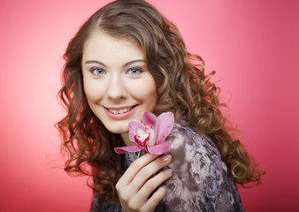woman with orchid flower over pink background
