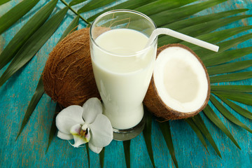 Coconuts with glass of milk,  on blue wooden background