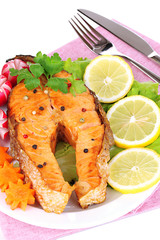 Appetizing grilled salmon with lemon and vegetables close up