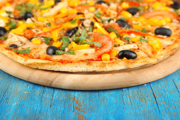 Tasty pizza on blue wooden table close-up