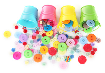 Colorful buttons strewn from buckets isolated on white