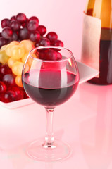 Glass of wine with lipstick imprint, grapes and bottle