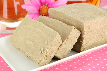 Tasty halva with tea on table close-up