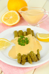 Asparagus on plate, on wooden background