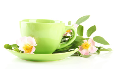 Cup of herbal tea with hip rose flowers, isolated on white