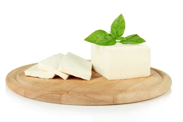 Fototapeten Sheep milk cheese with basil on cutting board, isolated on © Africa Studio