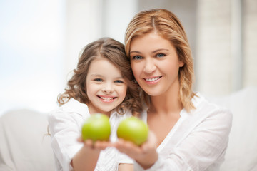 Fototapeta na wymiar mother and daughter holding green apples