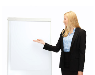businesswoman pointing at white blank flipchart