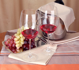 Vine and glasses on round table on cloth background