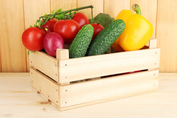 Fresh vegetables in box on wooden background