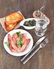 Bacon on plates on wooden table