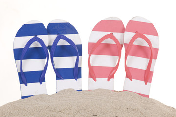 Flip-flops in sand isolated over white background.