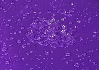Water drops on purple plastic background
