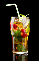 Iced tea with raspberries and mint on black background