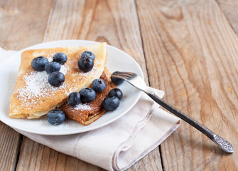 Crepes with blueberries and sugar powder