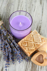 Obraz na płótnie Canvas Lavender candle with fresh lavender, soap on wooden background