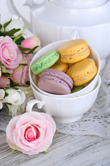 Macaroons in bowl on wooden table close-up