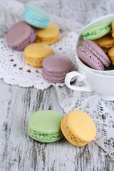 Macaroons in bowl on wooden table close-up