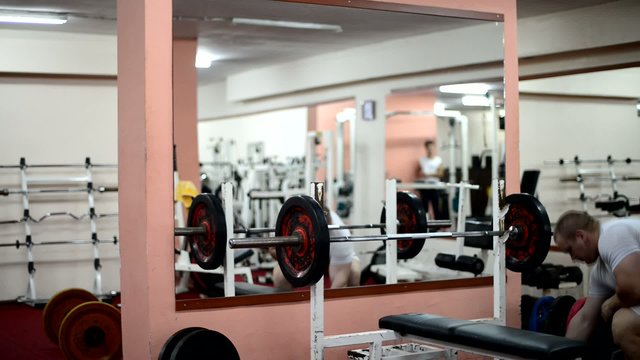 muscular man putting weights to workout