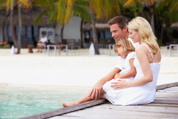 Family Sitting On Wooden Jetty