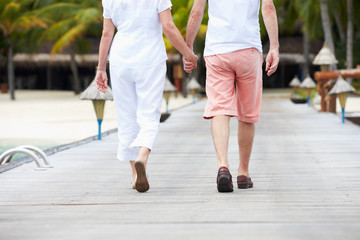 Detail Of Senior Couple Walking On Wooden Jetty