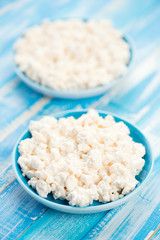Two saucers with fresh cottage cheese, vertical shot