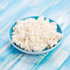 Fresh cottage cheese in a saucer, close-up