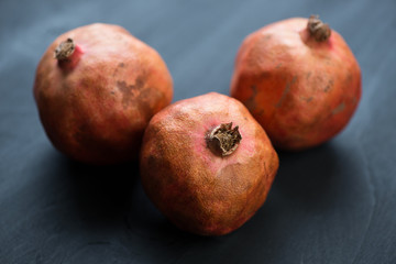 Pomegranates on black wooden boards, horizontal shot