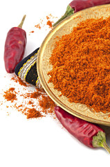 plate of chili red pepper powder and whole dried chili peppers
