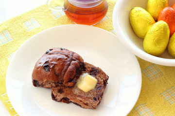 Chocolate hot cross buns with butter and easter eggs