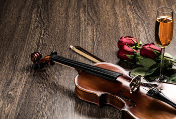 Fototapeta premium Violin, rose, glass of champagne and music books