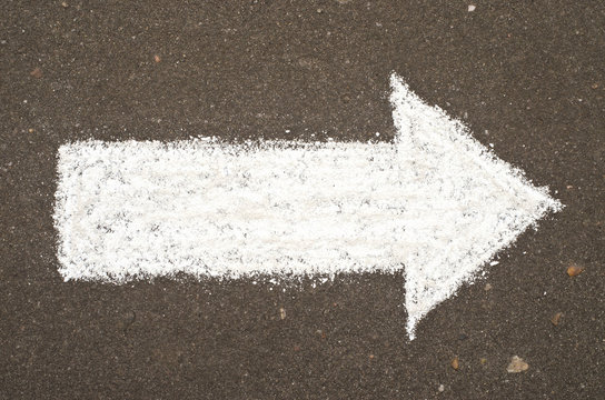 Hand drawn arrow on asphalt