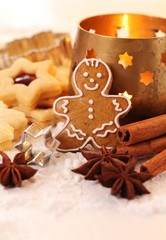 Gingerbread man, shortbread cookies, spices and candle.
