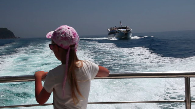 little girl on fast motor boat on sea, summer vacation