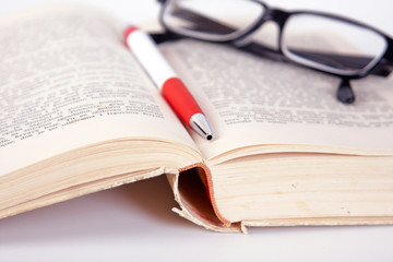 glasses and pen on the book