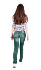 back view of walking  woman in jeans .