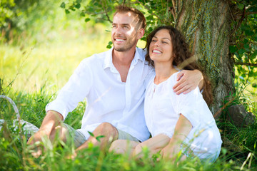Young Couple Having Picnic in a Park. Happy Family Outdoor