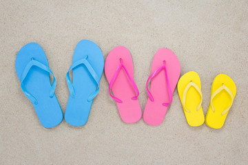 Fototapeta na wymiar colorful flip flops on sandy beach