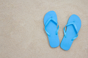 Fototapeta na wymiar blue flip flops on sandy beach