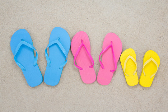 colorful flip flops on sandy beach