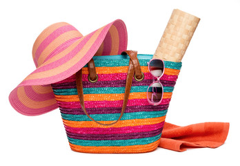 Colorful striped beach bag with a hat sun mat towel and sunglass - obrazy, fototapety, plakaty