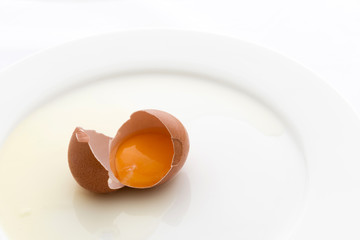 Broken egg on white dish