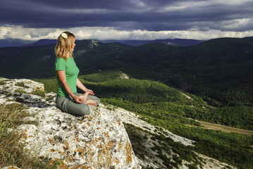 Naklejka premium Girl meditation at the mountains