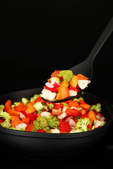 Vegetable ragout in pan, isolated on black