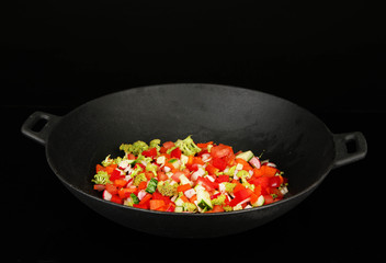 Vegetable ragout in wok, isolated on black