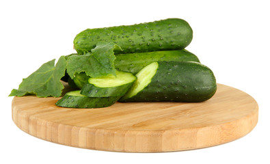 Tasty green cucumbers on wooden cutting board, isolated on